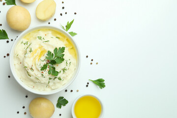 Plate of mashed potatoes and ingredients on white background