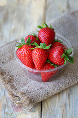 Fresh ripe strawberries in a plastic bowl. Large strawberries.