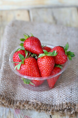 Fresh ripe strawberries in a plastic bowl. Large strawberries.