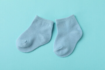 Pair of cute baby socks on blue background