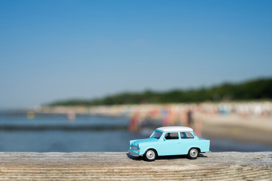 Baltic Sea - Germany - closeup of an old turquoise miniature car at the beach on a sunny day at the coast. Vacation concept. Retro car holiday.