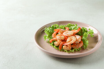 Plate of grilled shrimps on white textured table