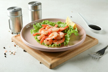 Plate of grilled shrimps on white textured table