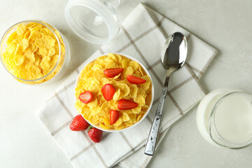 Concept of tasty breakfast with cornflakes on white textured table