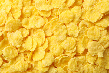 Dry uncooked corn flakes on whole background, close up