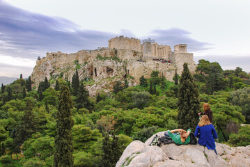 tourists resting on rock on the hike up to Acropolis of Athens.Greece