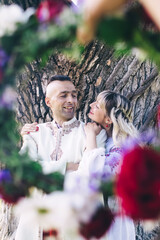 Young people are posing in traditional folk costumes. Cossacks man and woman in wreaths and...