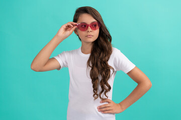 serious teen girl long curly hair in sunglasses casual style on blue background, summer style