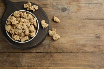 Dried soy meat on wooden table, flat lay. Space for text