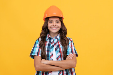 happy child with curly hair in construction helmet, contractor