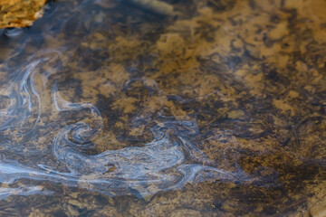 oil spills on puddle background, abstract gasoline nature pollution concept