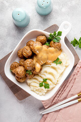 Traditional swedish meatballs with creamy sauce and mashed potatoes on gray table close up vertical photo