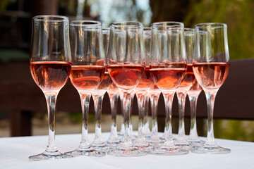 A lot of Glasses with Rose wine for guests at the buffet table. Close-up, selective focus
