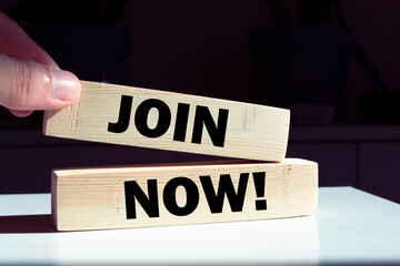 JOIN NOW! symbol. Wooden blocks with words 'JOIN NOW!' on beautiful orange background. Businessman...