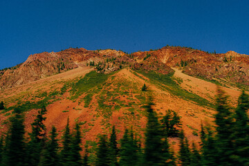 green fields on the background of the altai republic mountains
