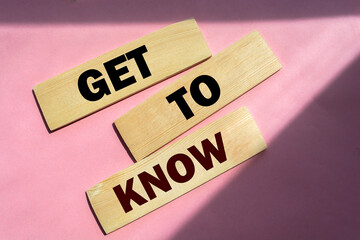 Get to know words on wooden blocks on pink background.
