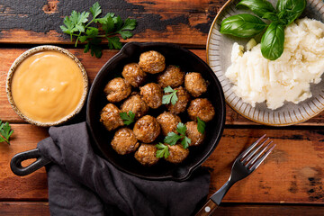  Traditional swedish meatballs with creamy sauce and mashed potatoes on old wooden background top...