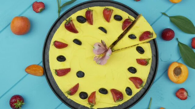 Sunny yellow cake. The custard is bright in color. Garnished with fresh berries. Strawberries, blueberries and more. blue background. Flat lay