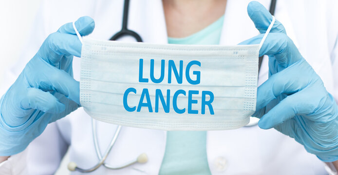 Lung cancer inscription on a disposable blue mask in the hands of a doctor, a medical concept - Powered by Adobe