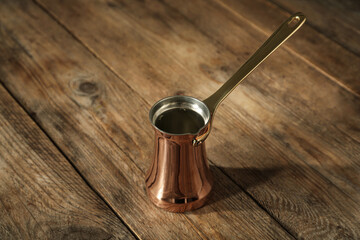 Beautiful copper turkish coffee pot on wooden table