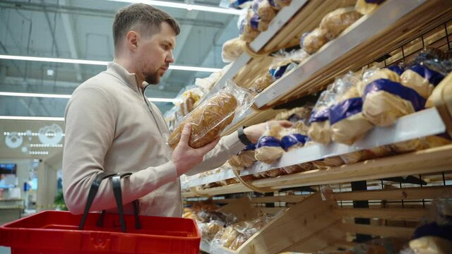 aisle with bread in supermarket, man is shopping alone in grocery
