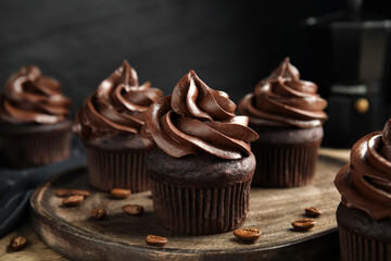 Delicious chocolate cupcakes with cream on wooden table