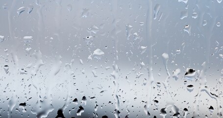 Streams of raindrops on window glass