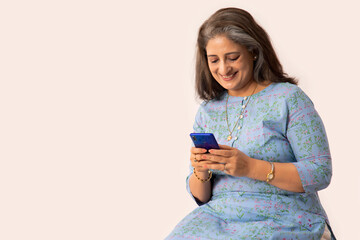 A SENIOR ADULT WOMAN HAPPILY USING MOBILE PHONE