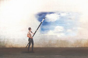 surreal woman with giant brush draws a sky on a city wall