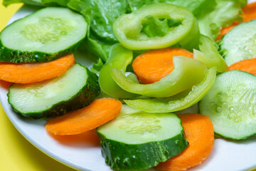 Delicious vegetable salad on a yellow background. Healthy diet food made from fresh vegetables. Vegetarian food
