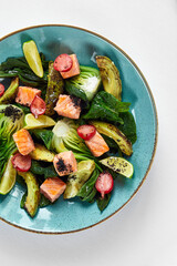 Salmon with artichokes, avocado, close-up, served by the chef with baked salmon and avocado with artichokes in lemon sauce