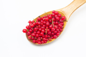 Red currants in a wooden spoon on a white background. Lots of ripe red currants. Delicious berry.
