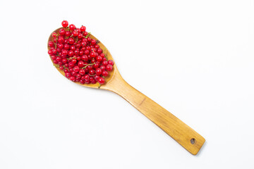 Red currants in a wooden spoon on a white background. Lots of ripe red currants. Delicious berry.