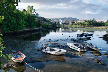 Embarcaciones y lanchas a motor varadas en la desembocadura del río Verdugo durante la marea baja en Ponte Sampaio, Pontevedra, España