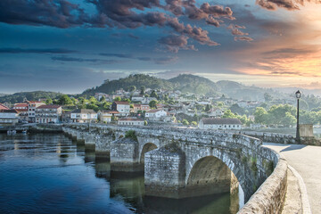 Amanecer nublado sobre el puente medieval de origen romano en la villa de Ponte Sampaio, provincia de Pontevedra, España - obrazy, fototapety, plakaty