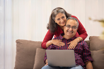 A HUSBAND AND WIFE HAPPILY LOOKING AT CAMERA AND POSING