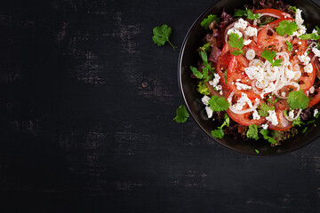 Vegetable salad with tomato, fresh lettuce, soft cheese and onion. Healthy diet food. Top view, above