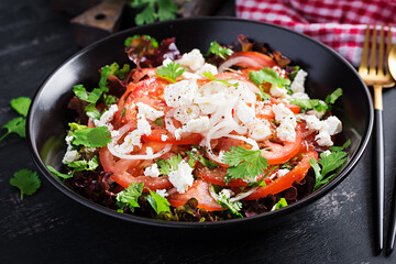 Vegetable salad with tomato, fresh lettuce, soft cheese and onion. Healthy diet food.