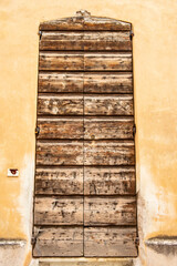 Old wooden door of a house with yellow wall