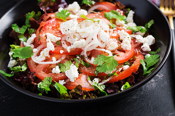 Vegetable salad with tomato, fresh lettuce, soft cheese and onion. Healthy diet food.