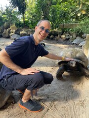 Jeune homme touchant une tortue terrestre