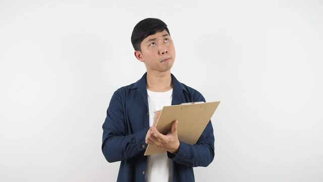 Asian man check list on wood board document in his hand and thinking about job white background
