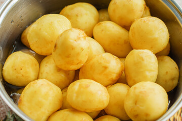 Fresh peeled potatoes are in a saucepan and ready for boiling