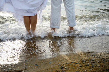 Couple on the seashore stand in the water 