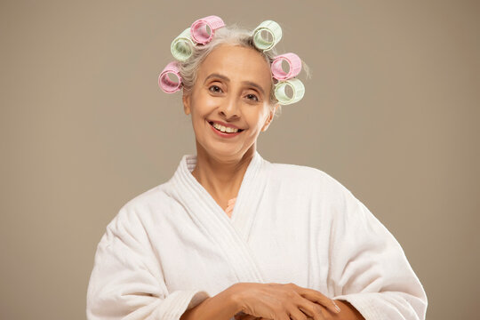 An Old Woman Styling Hair With Rollers.