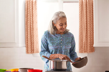 An old woman cooking in her kitchen.