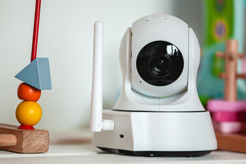 IP camera on the shelf with toys, serving as baby monitor