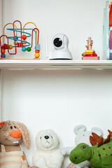 IP camera on the shelf with toys, serving as baby monitor