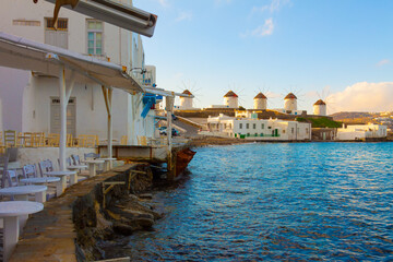 Widnmills distant view with cloudy sky from the heart of Little Venice in Mykonos Island Cyclades Greece