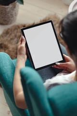 Young woman using digital tablet while sitting in a comfortable